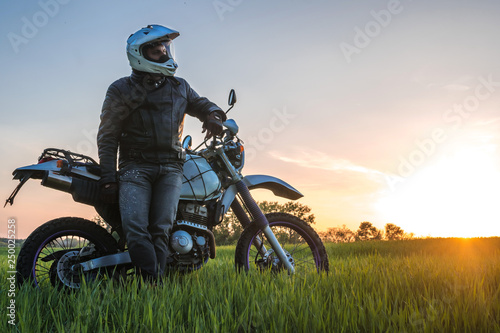 Motorcyclist on green grass off road, enduro, extreme sport, active lifestyle, adventure touring concept, enduro outdoor