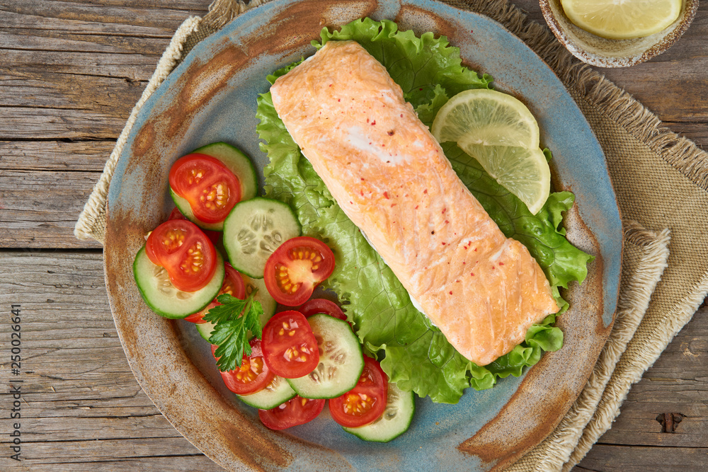 Steam salmon and vegetables, Paleo, keto, fodmap diet. Top view. Healthy diet concept, blue plate on old rustic wooden table