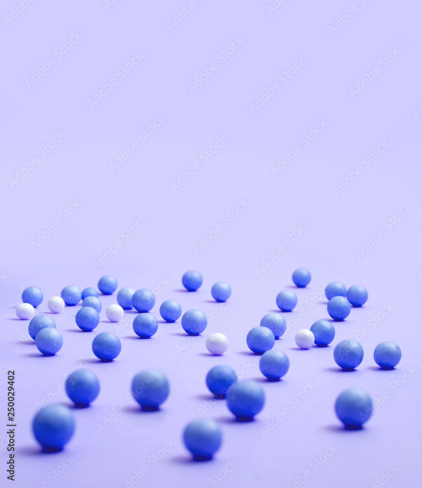 Blue and white balls are scattered on the lilac surface Blue and white balls are scattered on the lilac surface