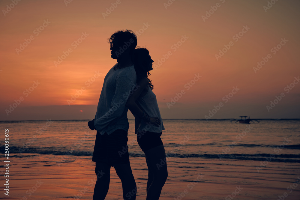 Silhouette of a girl in sunset / sunrise time over the ocean.