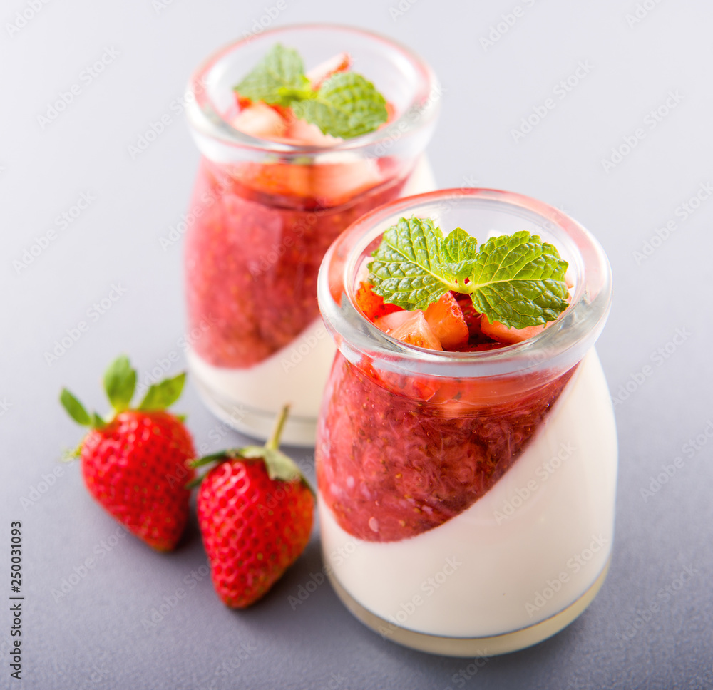 Delicous and nutritious double color (colour) strawberry desserts with mint and diced sarcocarp topping isolated with airy blue background, copy space, close up Delicous and nutritious double color (colour) strawberry desserts with mint and diced sarcocarp topping isolated with airy blue background, copy space, close up