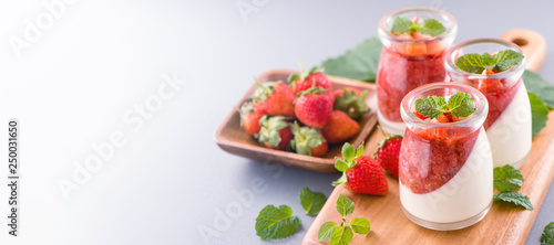 Delicous and nutritious double color (colour) strawberry desserts with mint and diced sarcocarp topping isolated with airy blue background, copy space, close up © RomixImage