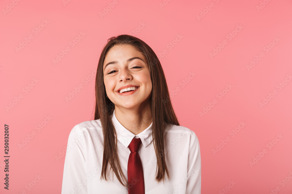 Portrait of caucasian girl 15-16y in school uniform standing, isolated over red background Portrait of caucasian girl 15-16y in school uniform standing, isolated over red background