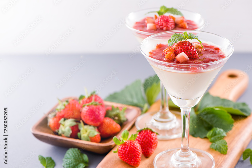 Delicous and nutritious double color (colour) strawberry desserts with mint and diced sarcocarp topping isolated with airy blue background, copy space, close up Delicous and nutritious double color (colour) strawberry desserts with mint and diced sarcocarp topping isolated with airy blue background, copy space, close up