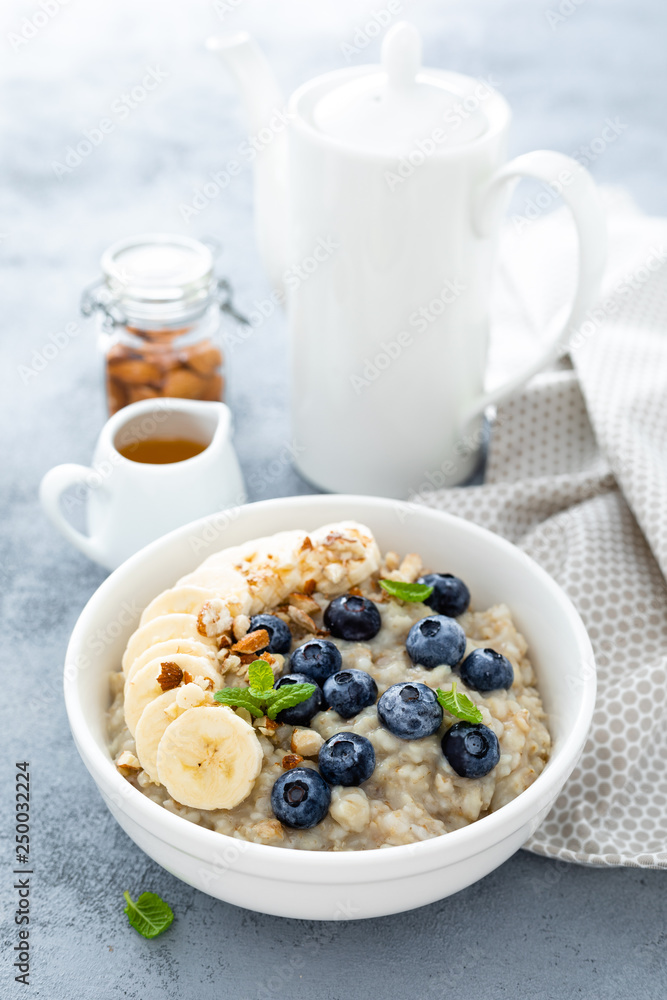 Oatmeal with fresh blueberry, banana, almond nuts and honey for breakfast Oatmeal with fresh blueberry, banana, almond nuts and honey for breakfast