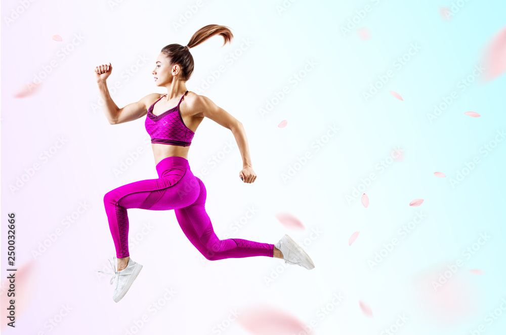 Young woman runner in purple sportswear jump in the air. Young woman runner in purple sportswear jump in the air.