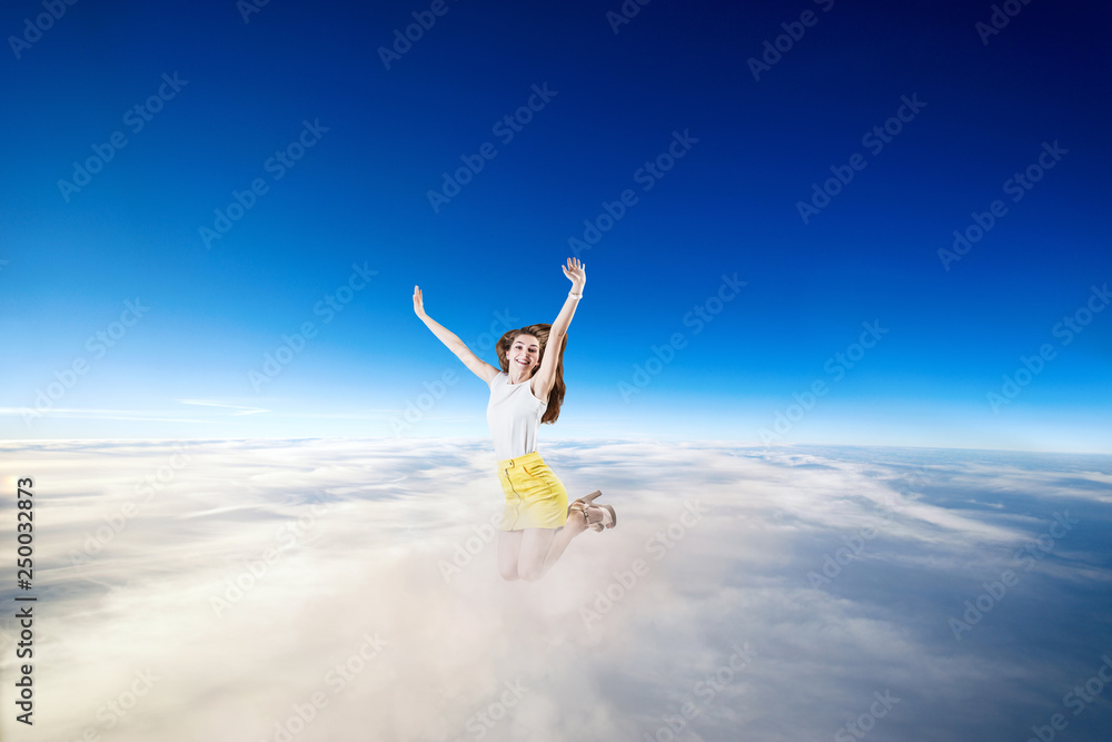 Young woman jumps in the blue cloudy sky. Young woman jumps in the blue cloudy sky.