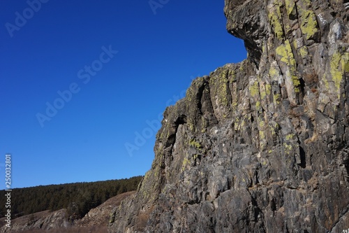 Mountain cliffs on the bank of the river against the blue sky