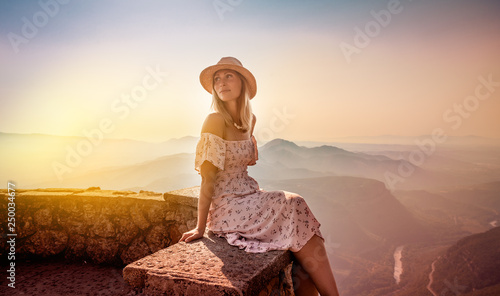 carefree female relaxing on top of the mountains