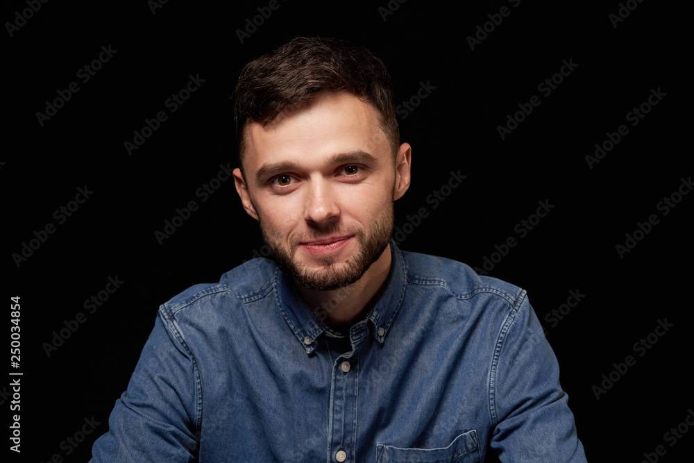 Handsome man in denim shirt looking at camera smiling