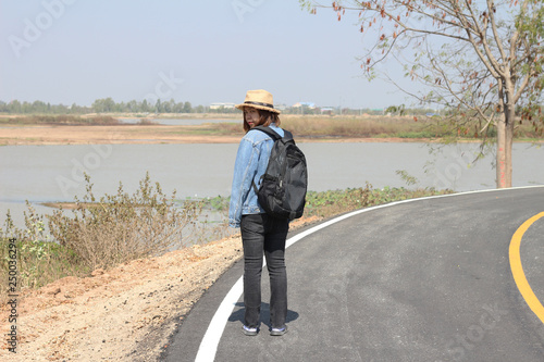 Girl in hat with backpack traveling on road, Travel concept.