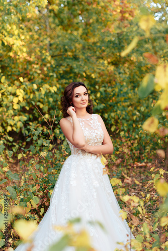 young beautiful bride walks in a summer Park with green leaves © ShevarevAlex
