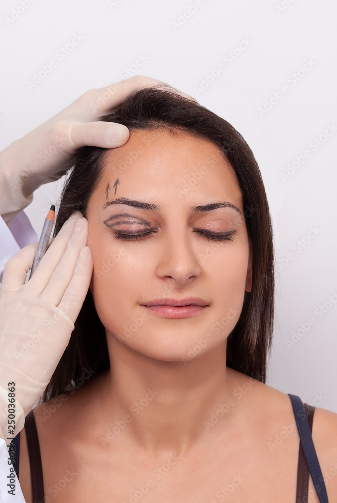 Portrait Of Beautiful Smiling Woman With Closed Eyes And Black Surgical Lines On Skin. Closeup Of Hands Touching Young Female Face. Plastic Surgery Concept.