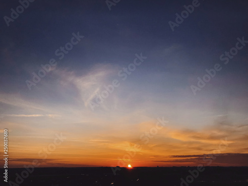 Beautiful amazing sunset, view of city and sky. Blue and yellow sky with sun and clouds, atmospheric scene of evening or morning. Dusk or dawn. Copy space © sonyachny