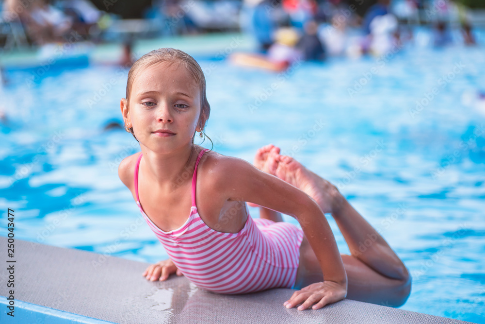 Beautiful little girl swims in the pool , cute little girl in pool in sunny  day.little girl . Stock Photo