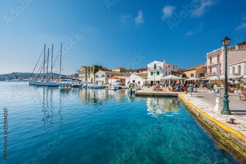 Old port Galios on Paxos island with anchored yachts  boat in background  street lamp in front
