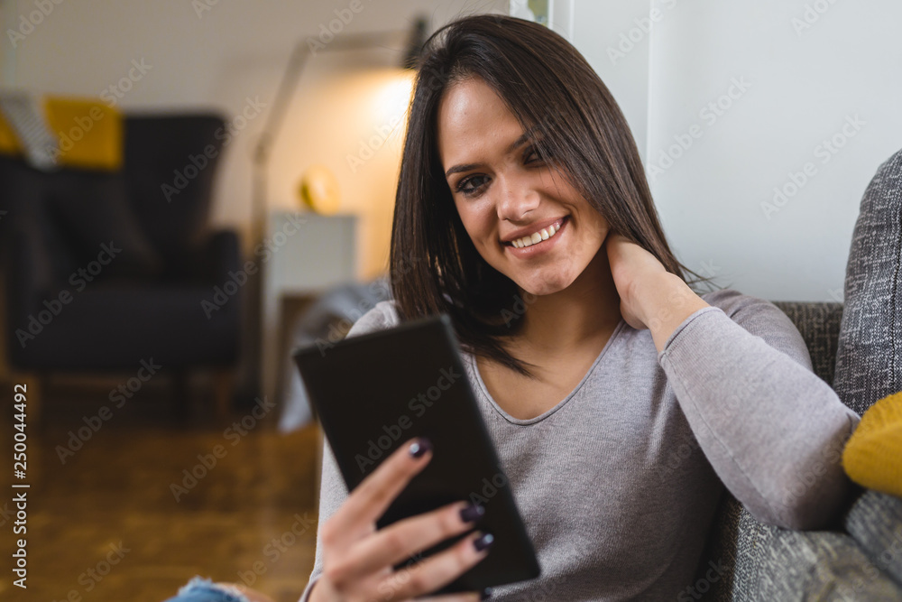 young woman reading news on tablet at her home young woman reading news on tablet at her home
