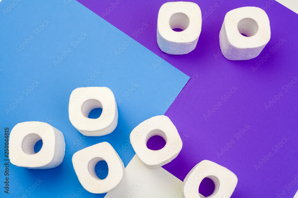Fototapeta premium Rolls of toilet paper on color background, top view