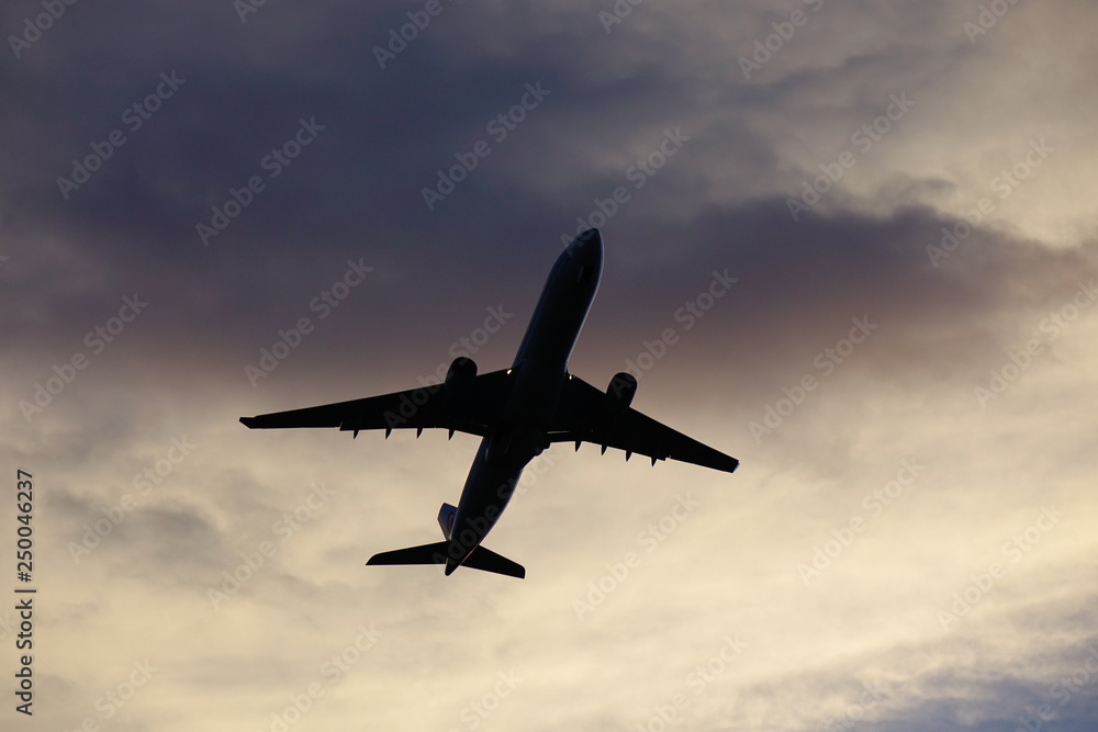 Passenger airplane taking off in sunset