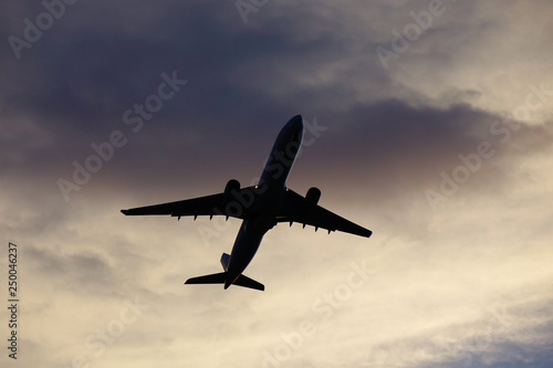 Passenger airplane taking off in sunset