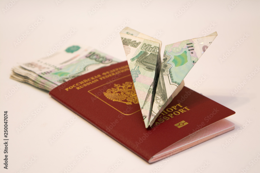 Airplane made of banknote, lying on the passport with money Airplane made of banknote, lying on the passport with money