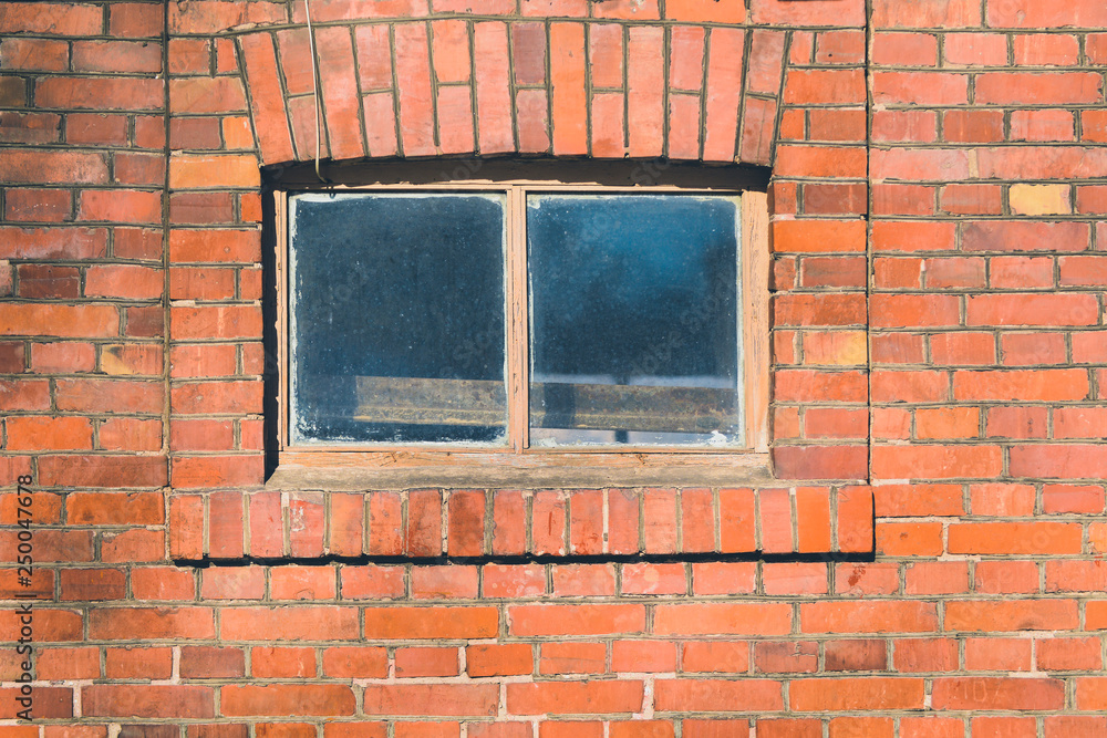 Small window in the middle of a red brick wall Small window in the middle of a red brick wall