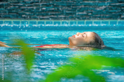 woman relaxing in swimming pool spa. Cute girl is relaxing in the pool.Relax pool spa.