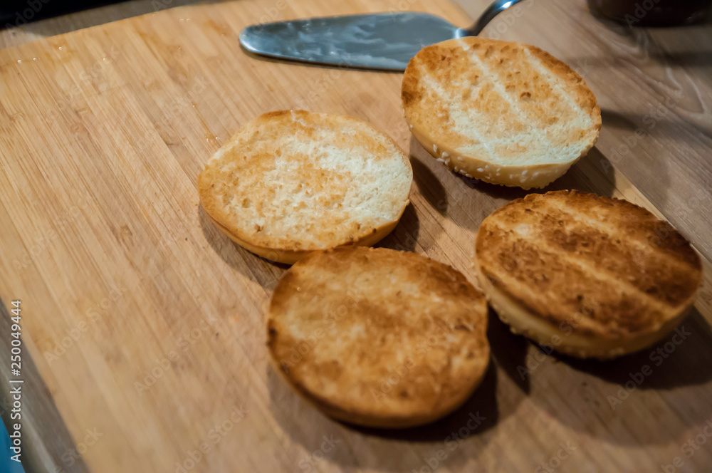 Burger buns with sesame seeds on a chopping board Burger buns with sesame seeds on a chopping board