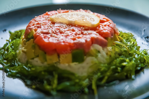 Hommemade kaisa salad with salmon, rice, avocado, sesame and lemon photo