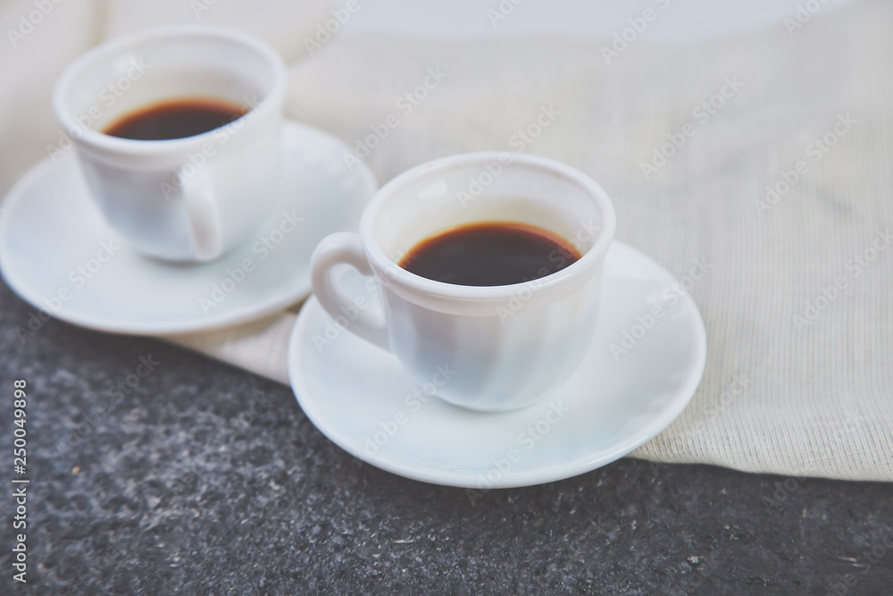 Two white cups of espresso on grey grunge background. Two white cups of espresso on grey grunge background.