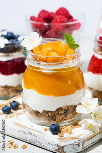 desserts with muesli, berry puree and fruit in jars, vertical