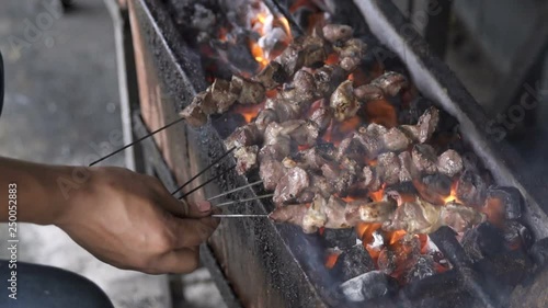 delicious sate or satay or meat being grill using traditional tool with charcoal photo