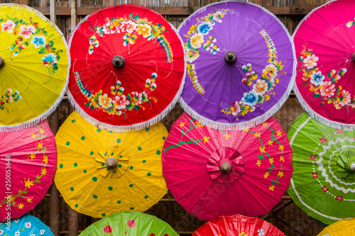 Colorful handmade paper umbrellas on wallpaper at thailand