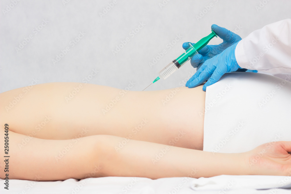 The doctor makes an injection of ozone and chondroprotector in the spine to the patient, ozone therapy, inflammation The doctor makes an injection of ozone and chondroprotector in the spine to the patient, ozone therapy, inflammation