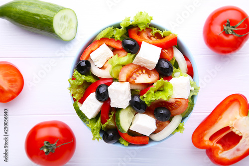 Fresh vegetable salad on bowl on white wooden background