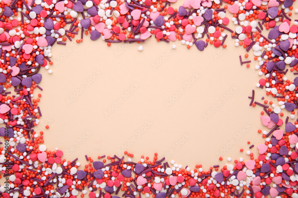 Colorful sprinkles on a beige background, top view with copy space