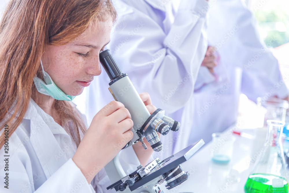 Εκτύπωση καμβά Little girl at an elementary school, using microscope research, testing in science class