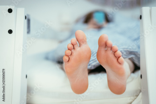 Naked feet of a young girl in bed, morning