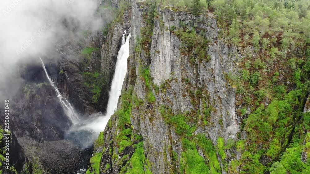 Voringsfossen waterfall, green summer mountains, Mabodalen canyon Norway. National tourist Hardangervidda route, touristroad Rv7, Eidfjord sightseeing tour Voringsfossen waterfall, green summer mountains, Mabodalen canyon Norway. National tourist Hardangervidda route, touristroad Rv7, Eidfjord sightseeing tour