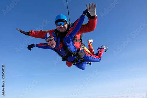 Tandem skydiving. Man and woman are falling in the sky together.