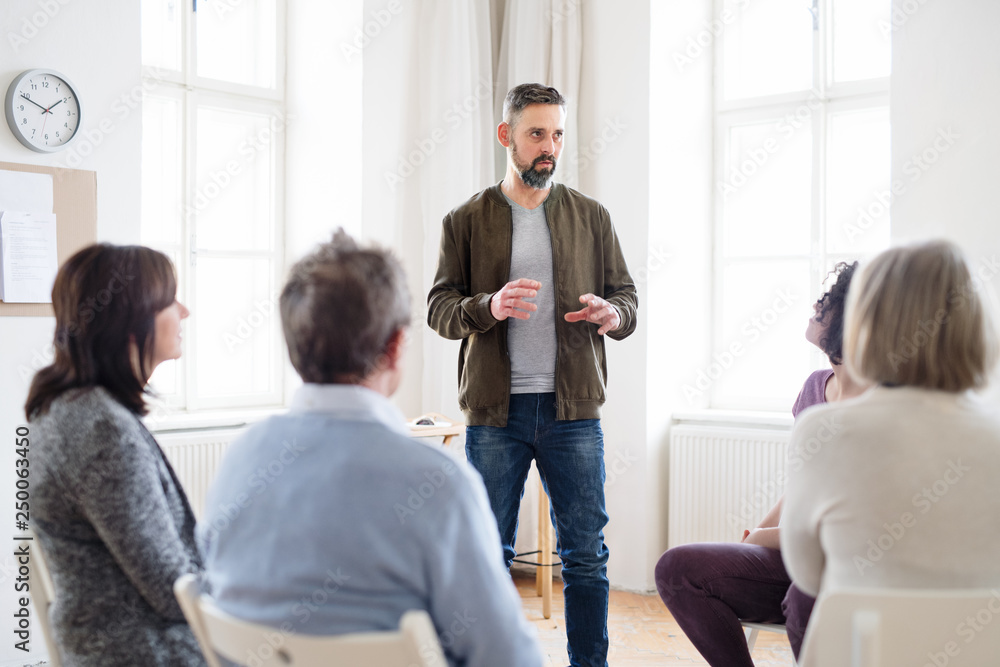 A man talking to other people during group therapy. A man talking to other people during group therapy.