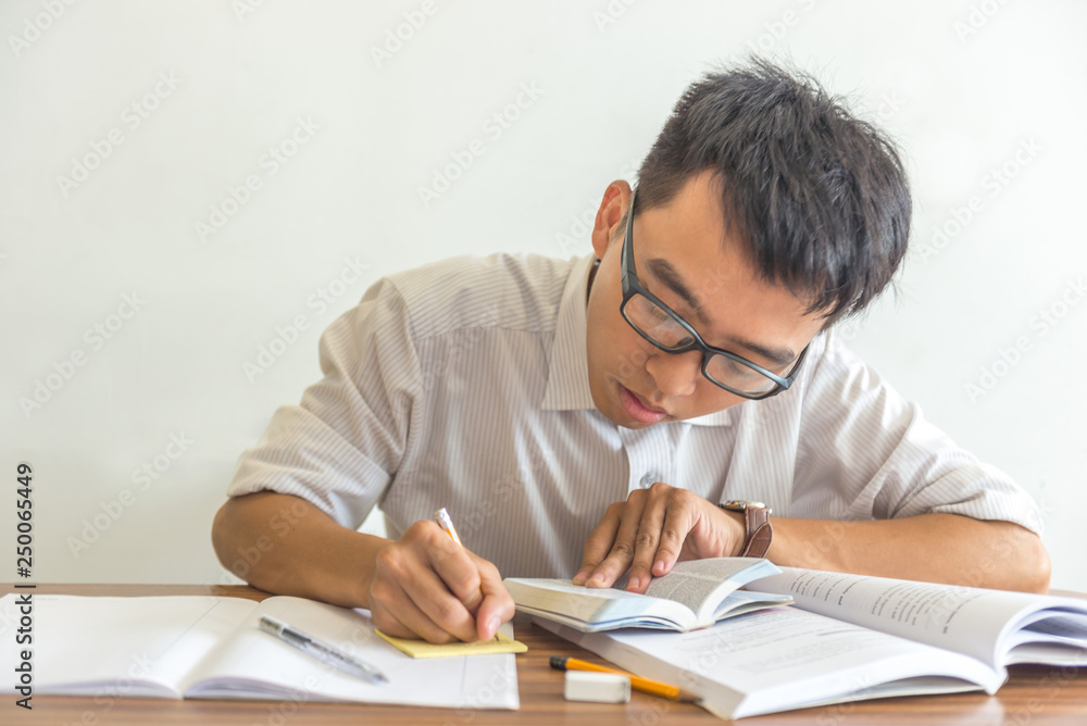 Asian student doing homework at the library Asian student doing homework at the library