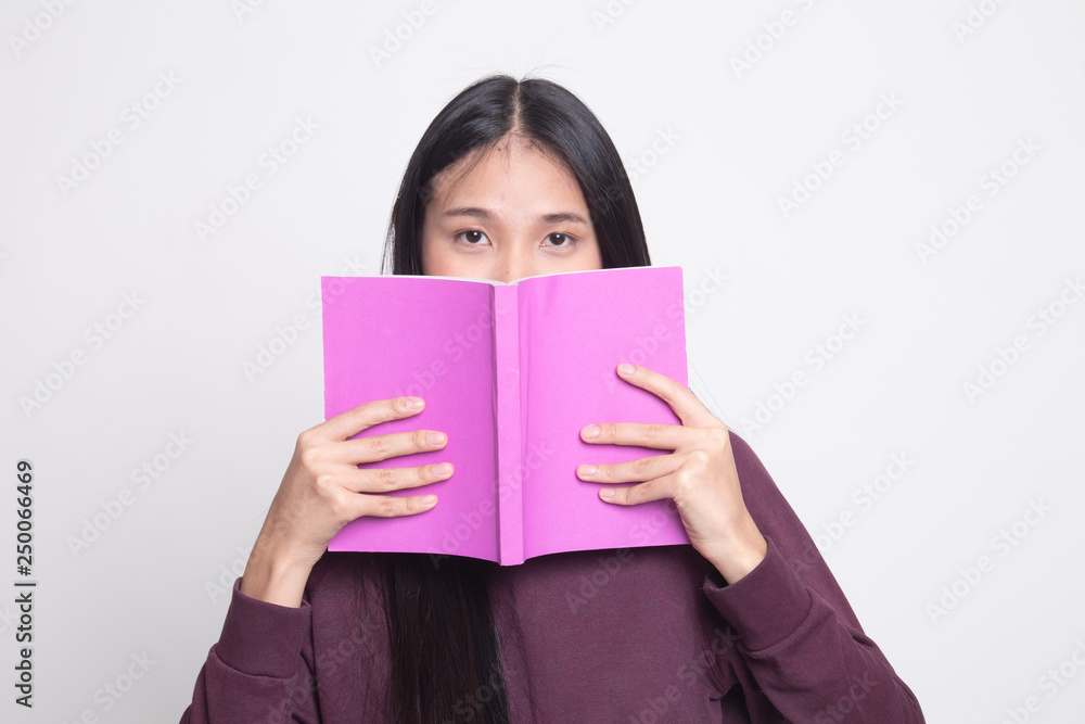 Young Asian woman with a book cover her face. Young Asian woman with a book cover her face.