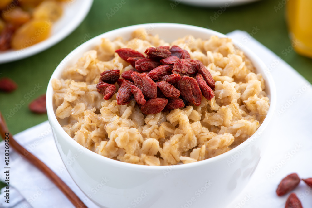 Oatmeal with goji berries in a white bowl. Healthy breakfast. Oatmeal with goji berries in a white bowl. Healthy breakfast.