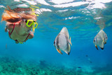 Happy family - active woman in snorkeling mask dive underwater, see tropical fishes in coral reef sea pool. Travel adventure, swimming activity and watersports on summer beach vacation with child.