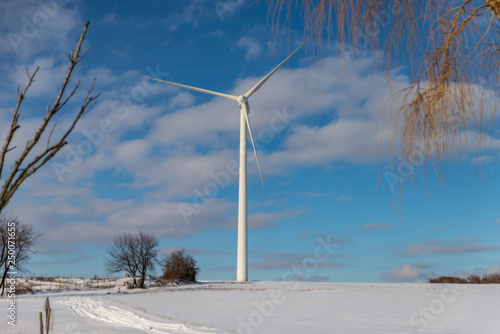 Grande éolienne dans un paysage en hiver avec de la neige sur fond de ciel bleu en Moselle © Olivier Piéton