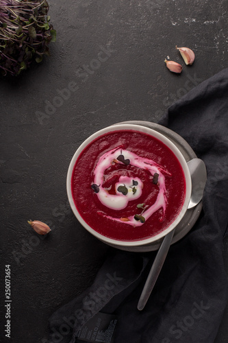 two plates with beetroot soup and sour cream on black background photo