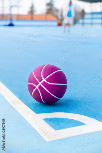 Boy practicing basketball sport on blue court and ball © Sergio