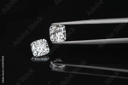 cushion diamonds with tweezer on black reflection background