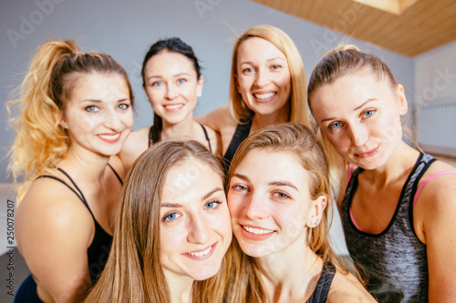 Group of young attractive women dressed in sportswear taking selfie in a sport dance, yoga, pilates studio.
